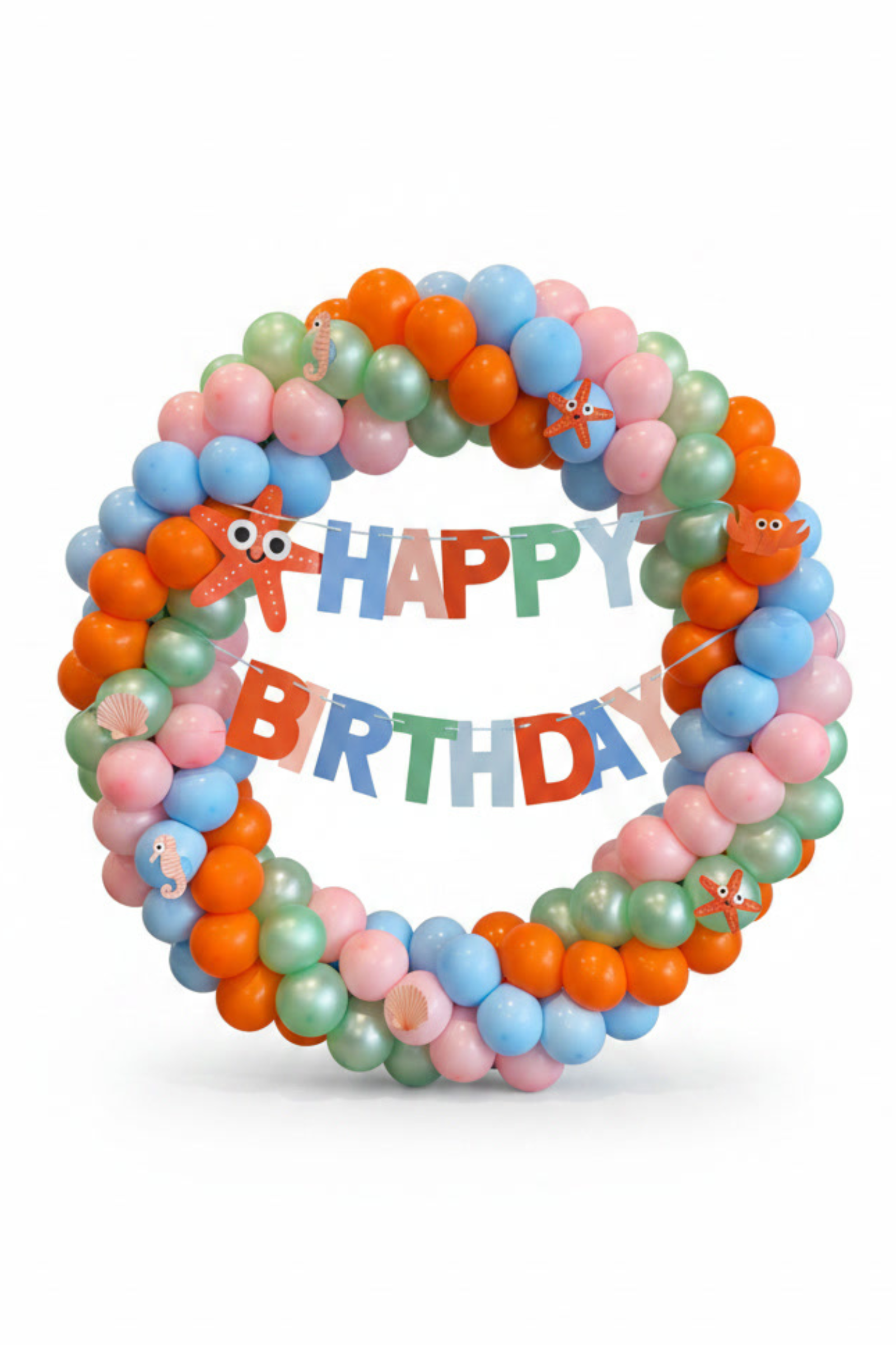 A colorful balloon garland arranged in a circle with a matching 'HAPPY BIRTHDAY' banner in the center, featuring pastel pink, light blue, mint green, and orange balloons with sea animals on a white background.